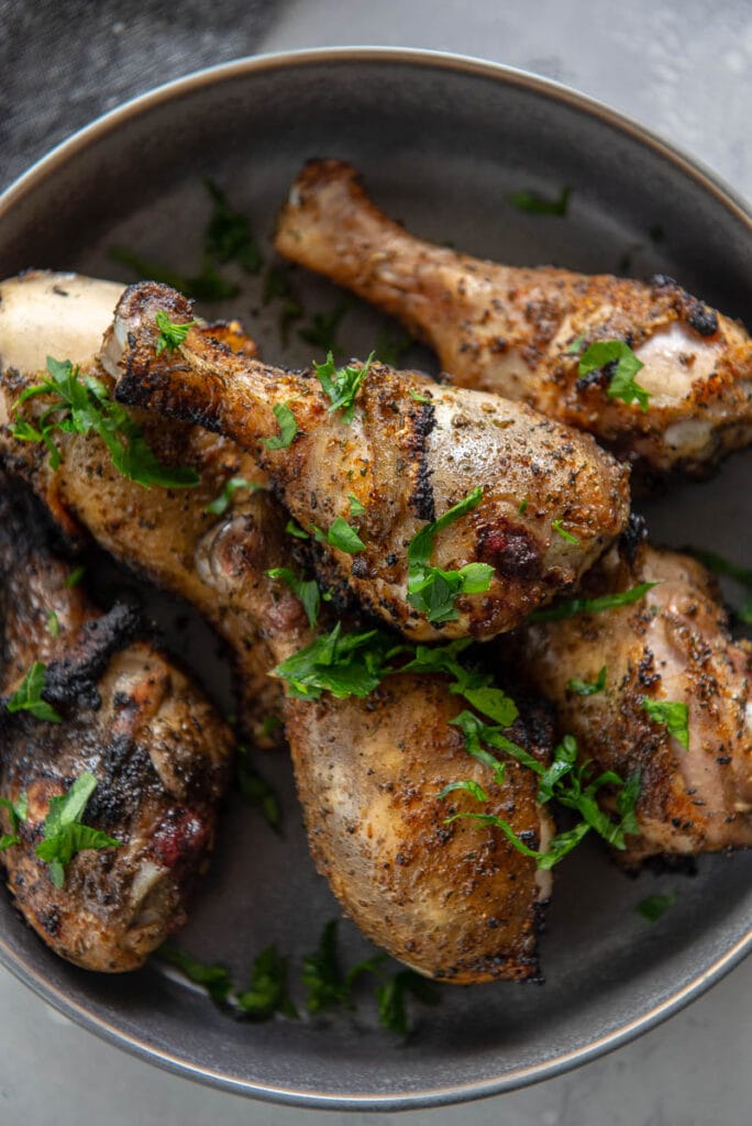 overhead view of grilled chicken drumsticks in a bowl