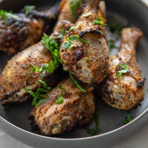 gray bowl with crispy grilled chicken drumsticks