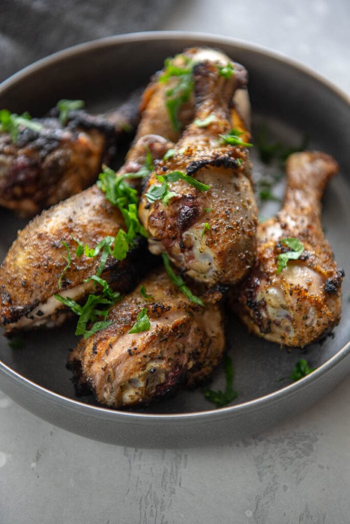 gray bowl with crispy grilled chicken drumsticks