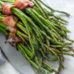 gray platter topped with grilled asparagus bundles wrapped in bacon