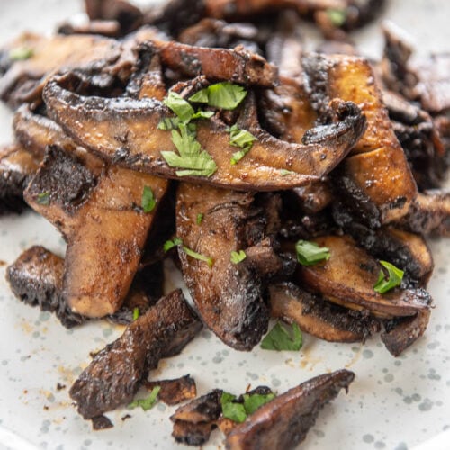 up close view of grilled mushrooms topped with chopped parsley