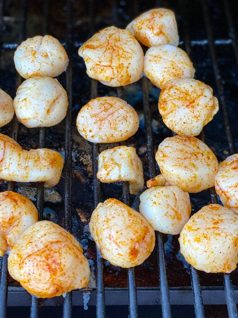 raw seasoned scallops directly on grate of grill