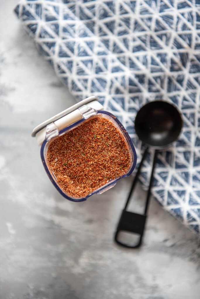 small plastic container filled with homemade cajun seasoning