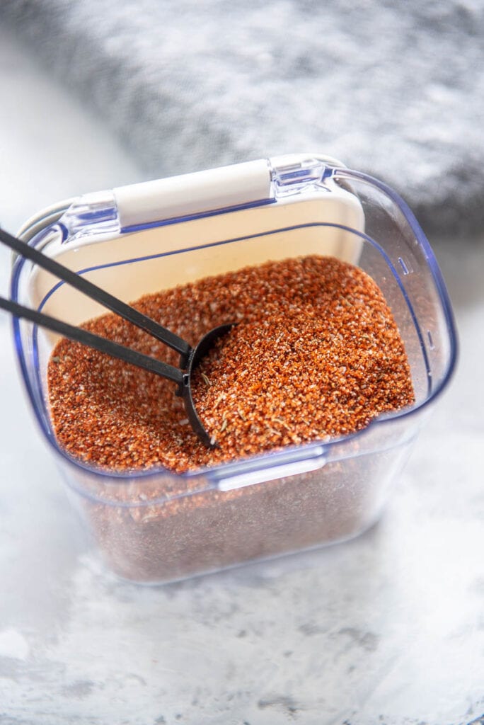 black tablespoon in plastic container of seasoning