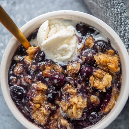 ramekin with blueberry crumble topped with vanilla ice cream