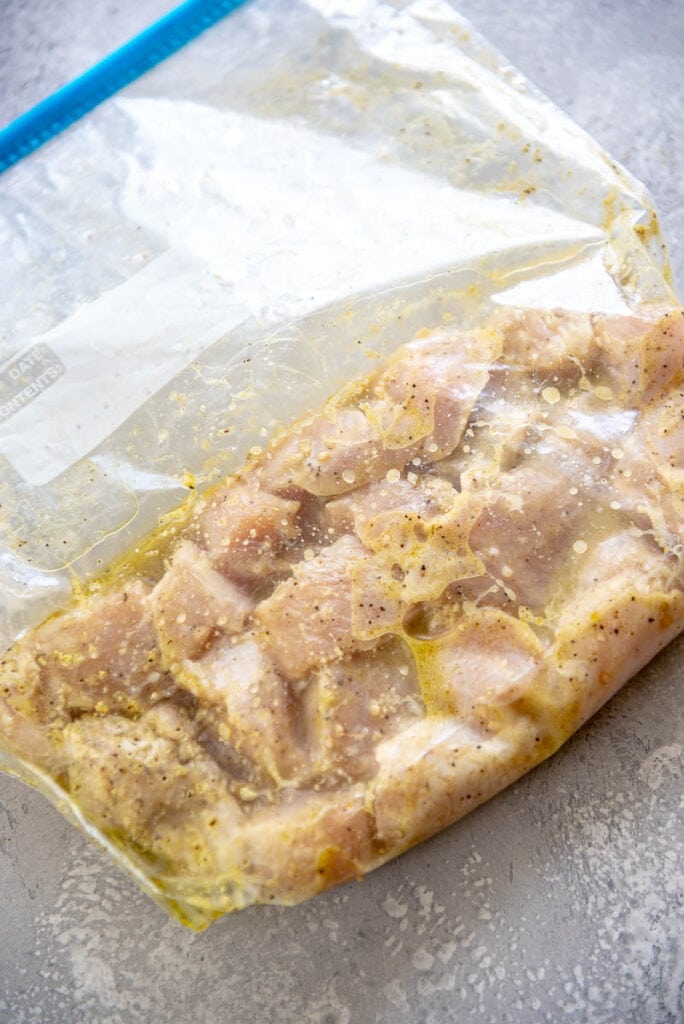 cut up chicken with marinade in plastic zipper bag