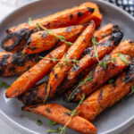 grilled carrots on a gray plate