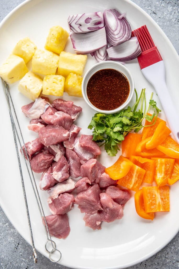 pork, pepper, pineapple and onion on platter ready to skewer