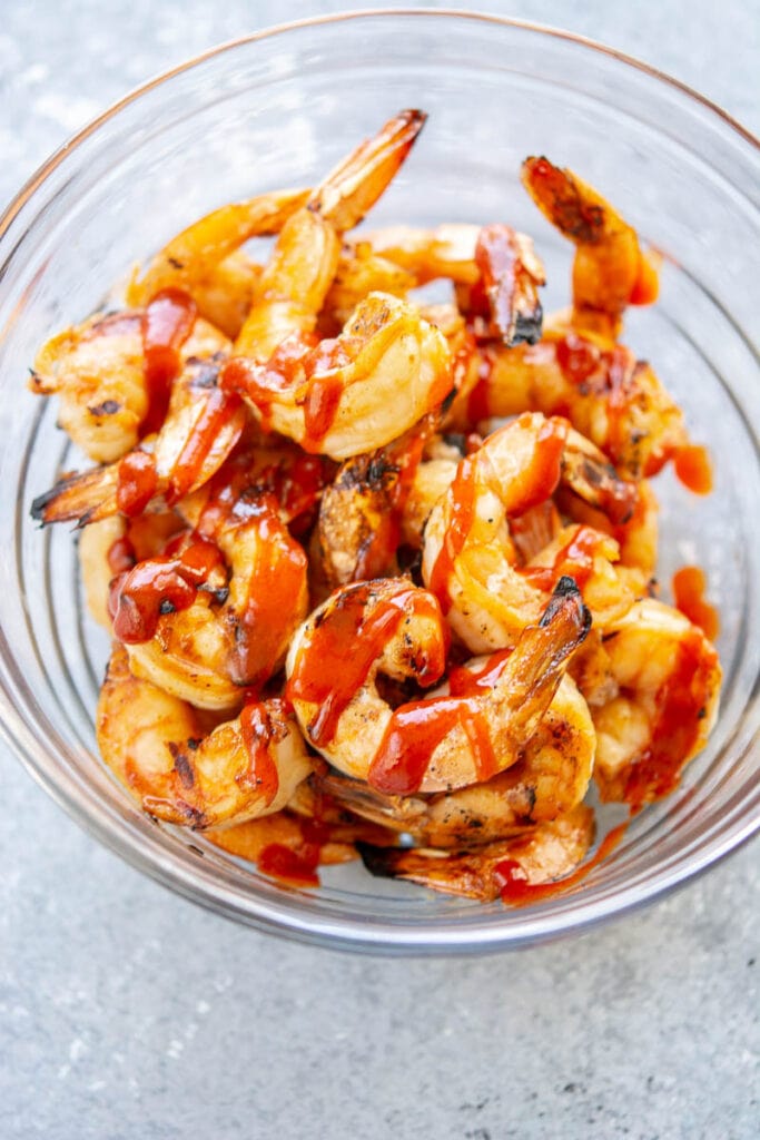 grilled shrimp with sriracha in a glass bowl