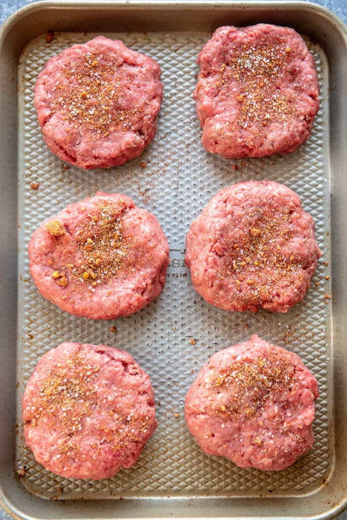 raw burger patties on a grill pan